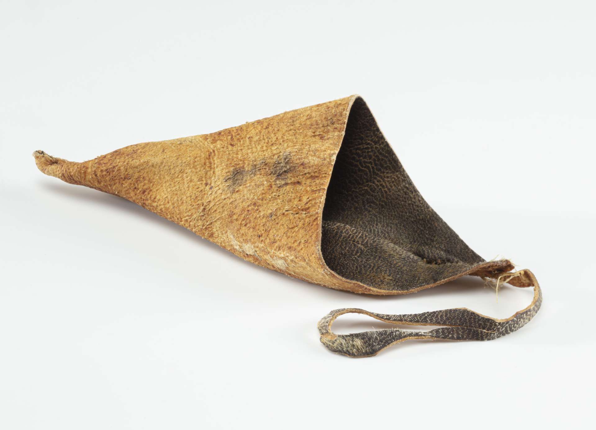 Pochette conique en peau de phoque brun avec une lani&egrave;re &eacute;troite fix&eacute;e &agrave; l&rsquo;extr&eacute;mit&eacute;. L&rsquo;int&eacute;rieur pr&eacute;sente une texture plus sombre et lisse.